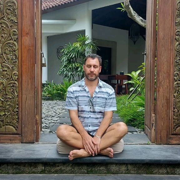 Jahben seated in a calm meditative pose